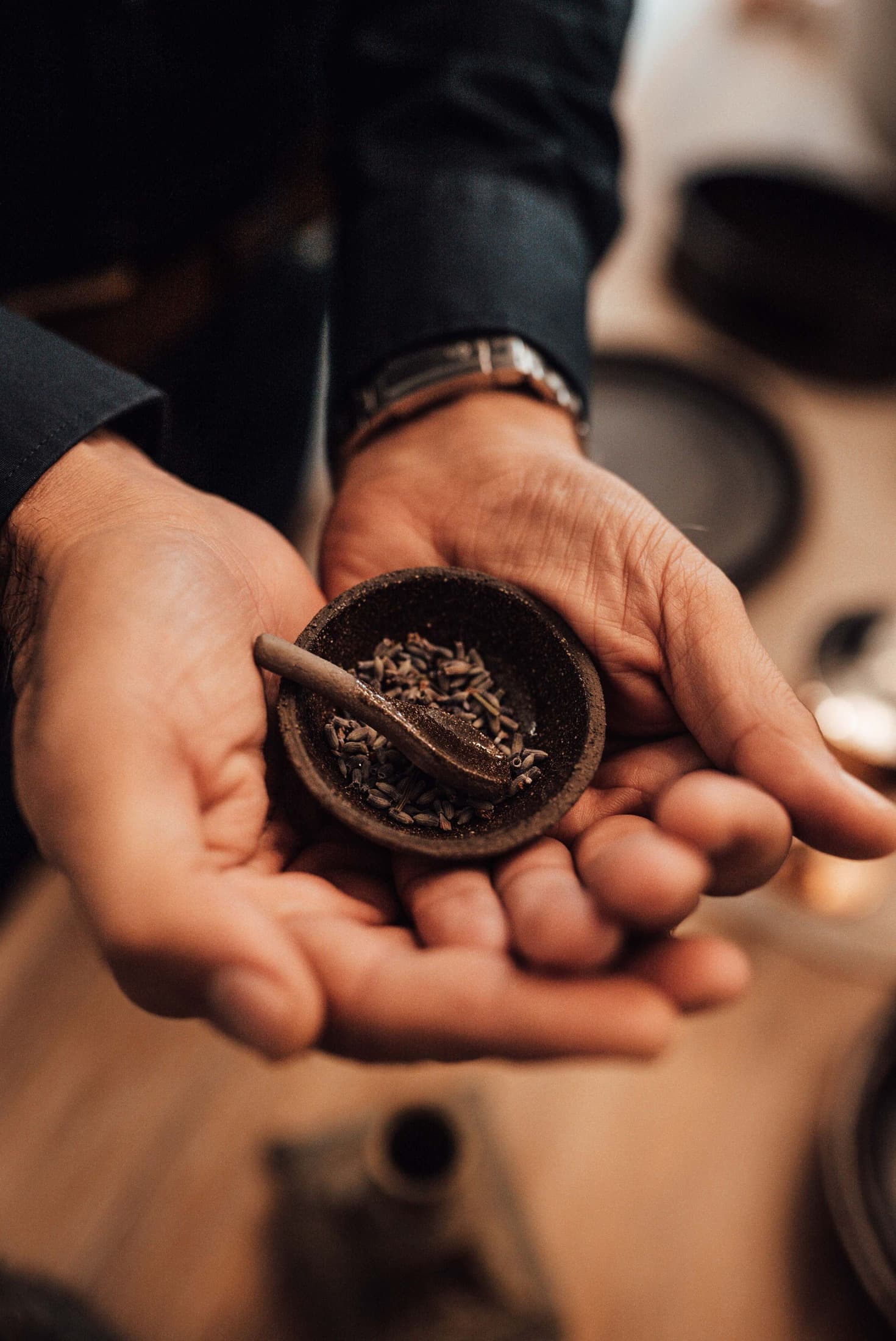 Hands holding a bowl of cumin seeds